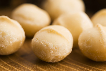 Roasted Macadamia nuts on rustic wooden background
