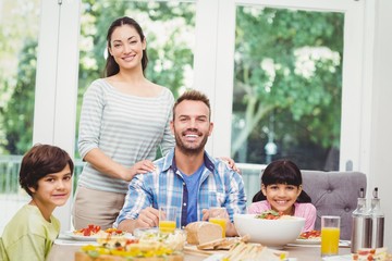 Portrait of cheerful family at dining table 