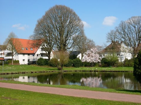 Gr&uuml;nanlage mit Fu&szlig;weg f&uuml;r Spazierg&auml;nger bei blauem Himmel und Sonnenschein am Meierteich im Stadtteil Schildesche in Bielefeld im Teutoburger Wald in Ostwestfalen-Lippe