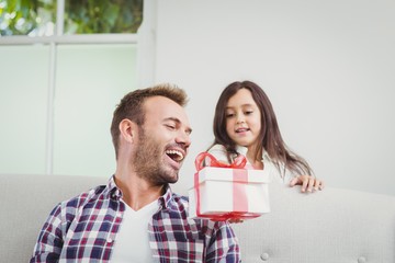 Smiling daughter giving gift to father 