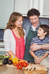 Happy parents with son in kitchen