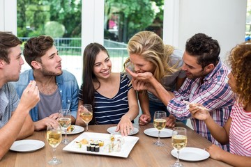 Friends enjoying wine and sushi at home