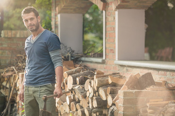 Young man cut wood in the garden