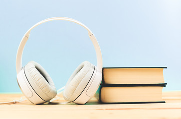 Fototapeta na wymiar Concept of audiobook. Books on the table with headphones put on them