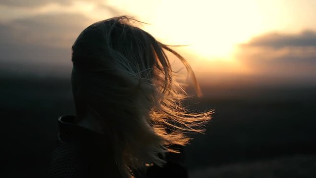 Beautiful girl watching the sunset and smiling, solar flare