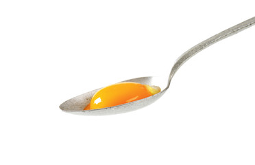 Raw egg yolk on spoon
