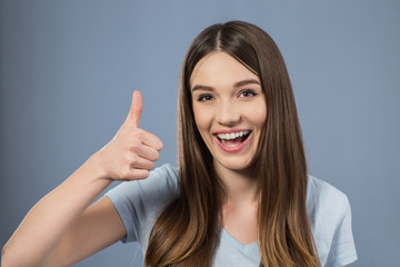 Cheerful charming girl thumbing up