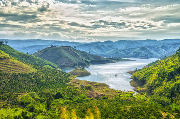 Sunset hillside Ta Dung hydro lake with mountains blue swirled large lake with islands, far away from the real little house idyllic rural countryside scene Vietnam