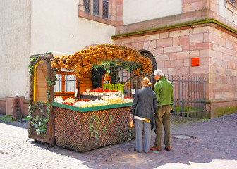 Tourists near Counter with fresh asparagus and strawberry in Heidelberg