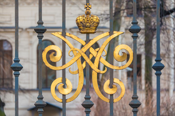 Wrought iron fence with a gilded monogram. Alexeevsky Palace, St. Petersburg, Russia.
