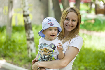 Mother and little son play in summer park