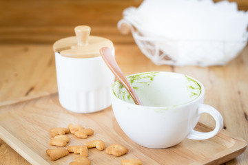 Green tea stains  a cup of coffee and on a wooden tray with a sn