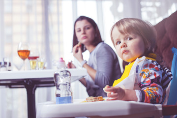 Mother with baby eating in a restaurant.