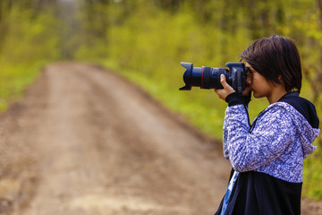 Fototapeta premium young photographer who takes pictures in forest
