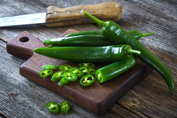 Fresh green chilli on old wooden background