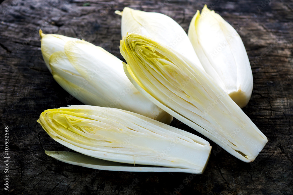 Wall mural fresh chicory salad on rustic wooden table.