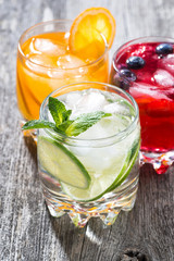 assortment of fresh iced fruit drinks on wooden background