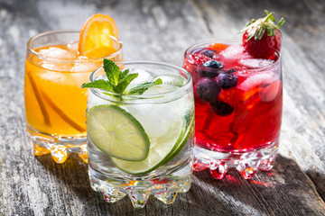 assortment of fresh iced fruit drinks on wooden background © cook_inspire