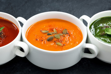 assortment of fresh vegetable soup on black background, closeup