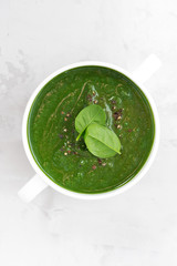 colorful spinach cream soup on a white background, top view