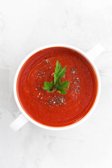 colorful tomato soup on a white background, top view