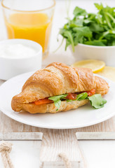 croissant with salted salmon and arugula, closeup, vertical