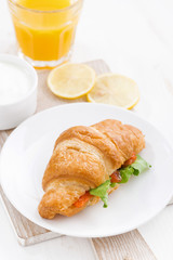 croissant with salted salmon and fresh arugula, top view