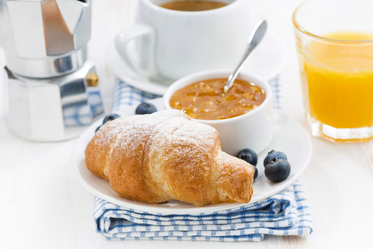 fresh croissant with orange jam and blueberries