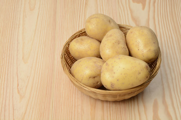 Fototapeta na wymiar Patatas crudas en un canasto de mimbre
