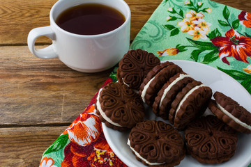 Chocolate cookies sandviches and cup of tea