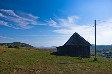 Rural wooden house at Pešter plateau panoramic landscape in southwest Serbia