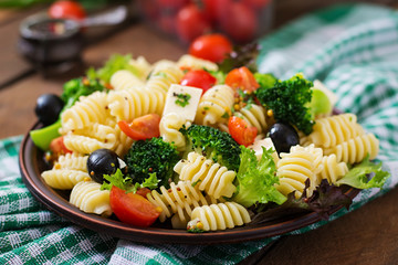 Pasta salad with tomato, broccoli, black olives,  and cheese feta