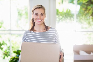 Portrait of young woman holding cardboard boxes