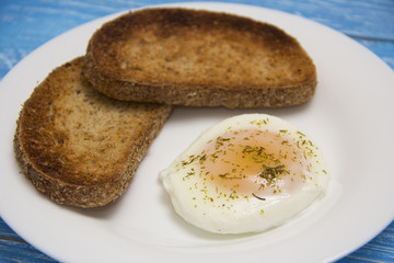 poached egg with two toasts on rustic background