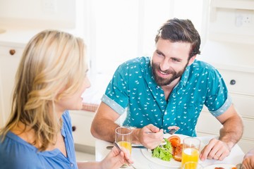 Young couple sitting at dining table talking