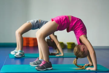 Gordijnen Girls doing gymnastic exercises or exercising in fitness class © dreamsnavigator