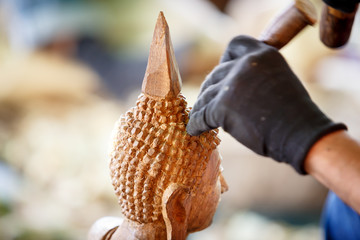 Hand of carver carving wood