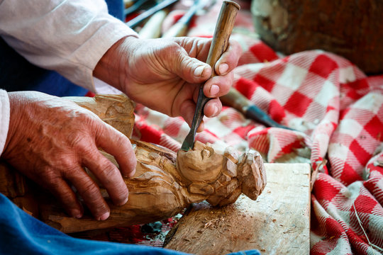 Hand of carver carving wood