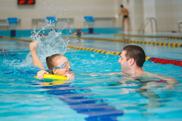 Obraz premium instructor teaches the girl swimming in a pool