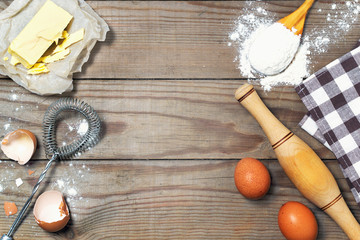 Eggs, flour, butter on the wooden table. Basic baking background