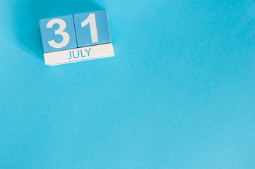 July 31st. Image of july 31 wooden color calendar on blue background. Summer day. Empty space for text