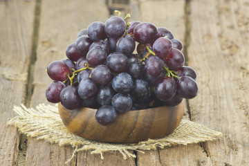 grapes in a bowl on wooden background