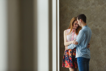 Naklejka premium man and woman near a large window.