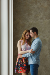 Naklejka premium man and woman near a large window.