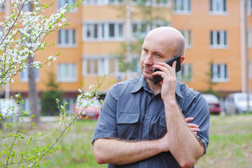 man with phone in background of a multistory building