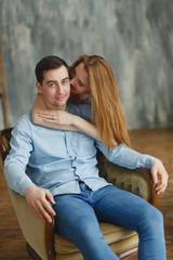 man and woman embracing in a chair new housing.