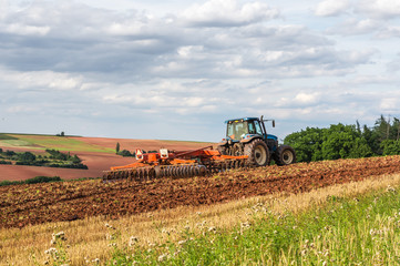 Fototapeta premium Farmer in tractor working on a field