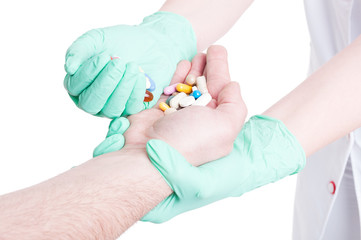 Female doctor giving various pills to a male patient