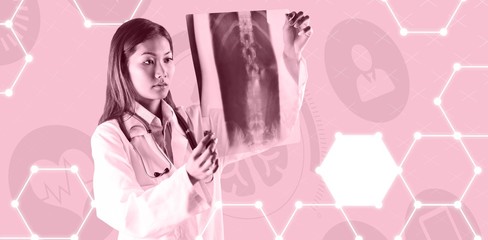 Obraz na płótnie Canvas Composite image of asian doctor checking mri scan