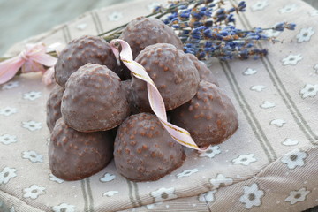 Black сhocolate with nuts, pink ribbon, blue lavender  closeup